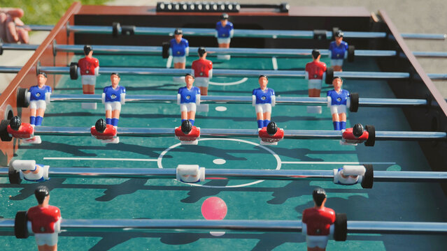 Table football game with red and blue players during a sports day