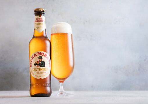 LONDON, UK - NOVEMBER 05, 2025: Bottle and glass of cold fresh Birra Moretti lager beer on light table background.