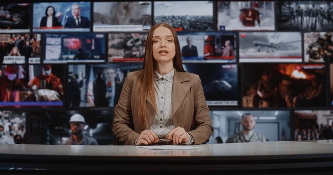 Woman TV Broadcaster Speaks to Camera in Advanced Studio Filled With Live News Screens. Global Information Exchange, Multimedia Journalism, and Professional Broadcast Standards in Media Industry.