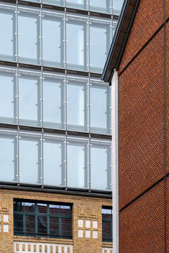 Modern facade composition showing brick building with glass windows in a grid where texture meets contrast creating clean architectural pattern and detail view