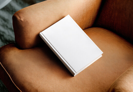 Minimal blank book cover on cozy armchair Mockup &ndash; Lifestyle interior scene &ndash; Generative ai