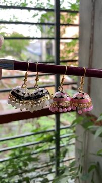 Shiny women accessories. holding silver earring Jumka. Vintage Jewelry Beautiful Earring For Beautiful Lady Multicolor Vintage Spain Jewelry.