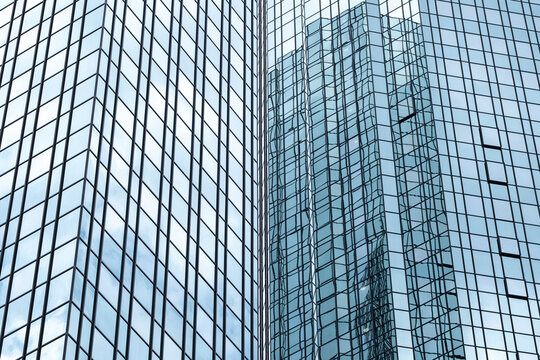 Abstract reflection on glass facade windows of modern corporate skyscraper towers creating sleek architecture background for finance and business branding