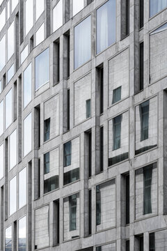 Abstract urban grid on concrete facade of modern office building with windows creating strong architecture background for corporate business concept