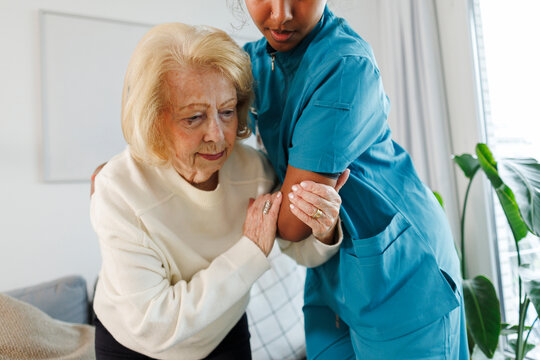 Caregiver helping elderly at home in supportive healthcare setting