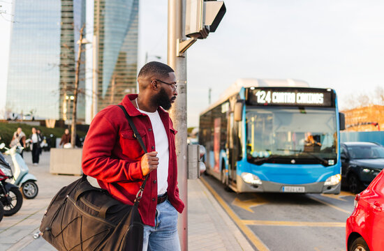 Urban man waiting by a bus in a city environment