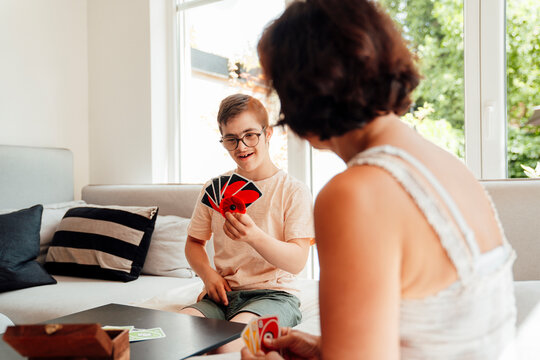 Mother and son playing card game at home fostering trust and connection