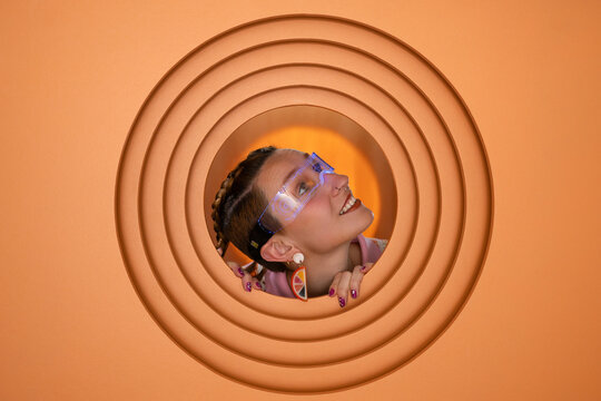 Portrait with futuristic glasses in orange geometric setting