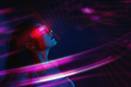 Woman using VR set with neon lights in futuristic cyberspace