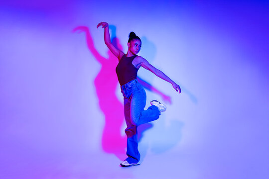 Fashionable woman posing in neon lights in a studio