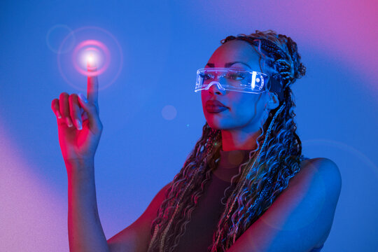Woman with braids using AR glasses and interacting in a studio