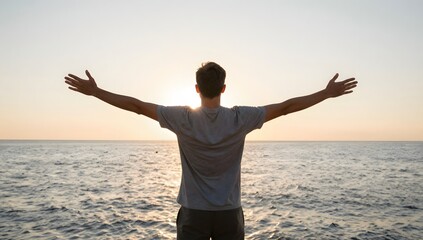 Fototapeta premium Young man embraces the sunrise over the ocean with open arms