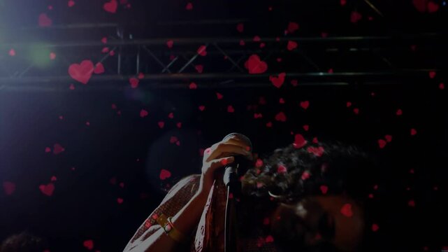 Woman music singer with mic singing, causing animated red hearts filling frame while swinging hair
