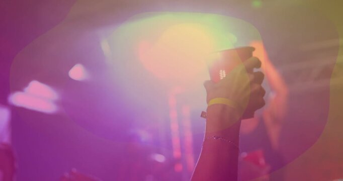 Crowd forearm raising red cup as music building, animated flares circling cup, crowd cheering