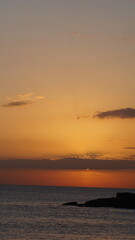 This breathtaking image captures a serene sunset over the calm ocean, highlighting the beautifully blended orange and yellow hues in the sky during twilight. © Aperezer