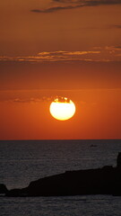 This breathtaking sunset captures the sun descending over the ocean, painting the sky with hues of orange, while gentle waves reflect the warm light beautifully. © Aperezer