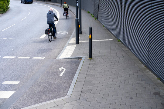 Cyclist riding a bicycle through an urban street intersection with lane and pavement showing transportation commute in hamburg with clear markings