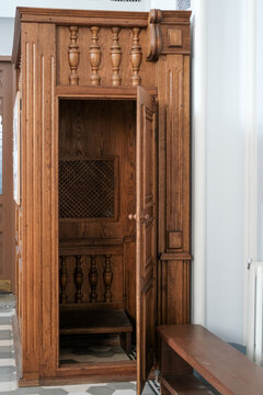 Traditional wooden confessional booth inside a Catholic church. Concept of religion, faith, sacrament of confession, and sacred architecture.