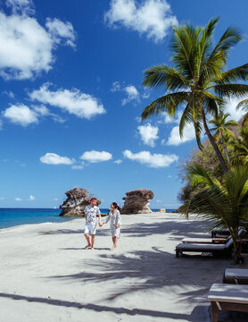 Explore breathtaking beaches of Saint Lucia with a couple walking hand in hand under the sun