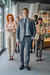 Fototapeta premium Confident business leader standing with diverse team in office