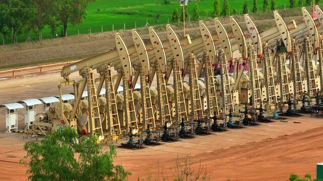 Aerial drone view of crude oil pumpjacks operating in rows, highlighting energy production infrastructure and the global demand for fossil fuels in today&rsquo;s evolving energy landscape.

