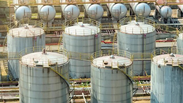 Overhead drone video of an industrial oil refinery complex, reflecting real-world energy infrastructure supporting global fuel needs amid economic uncertainty and evolving energy policies.
