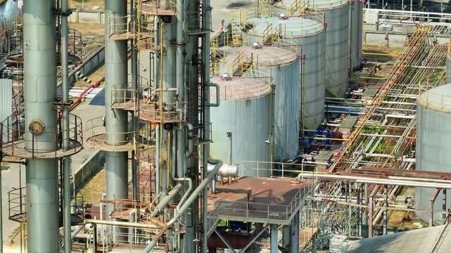 Drone image capturing refinery distillation units and metal tanks, emphasizing industrial fuel production as global economies navigate oil demand shifts and sustainability challenges.
