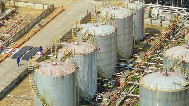 High-angle drone shot of refinery towers and storage tanks, illustrating large-scale oil refining operations shaped by geopolitical tensions, supply disruptions, and rising global consumption.
