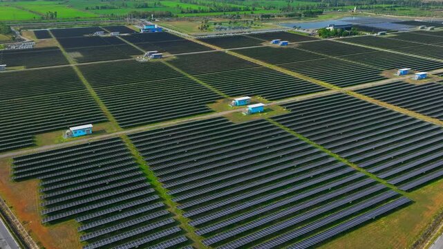 Drone perspective of expansive solar panels across open land, highlighting renewable energy systems supporting reduced carbon emissions and modern electricity demand worldwide.
