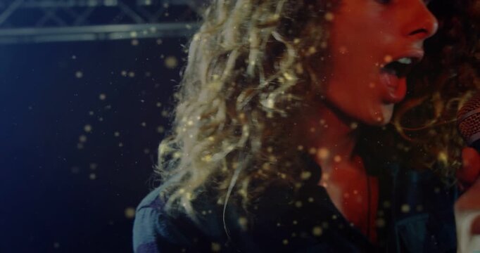 Singer gripping mic singing, head swinging stirring dust, camera pulling revealing concert lights