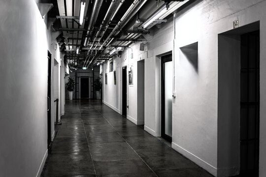 Prison corridor interior at former Central Police Station Tai Kwun in Hong Kong, China, with doors, industrial pipes and perspective hallway
