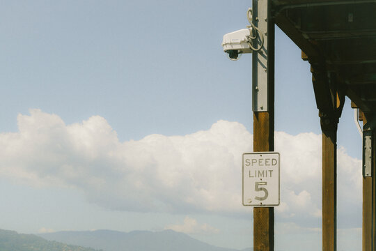 Speed limit sign and security camera on a wooden pier