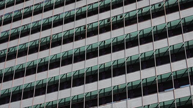 Modern industrial building facade with metal grid and sun shades.