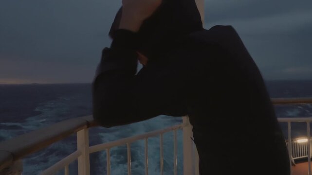 Positive young boy in a hooded jacket giving a thumbs up on the aft deck while facing a storm on the ferry from Denmark to Norway. A powerful 4K lifestyle moment of resilience and adventure at sea.
