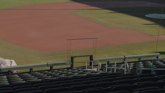 Slow steady right to left pan across empty baseball stadium seating and infield.