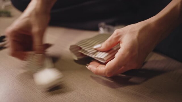 Hands Trim Striped Wrapping Paper With Scissors, Carefully Preparing a Christmas Gift - Close Up