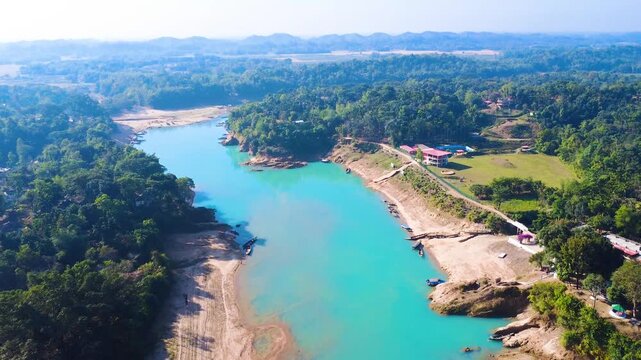 A scenic drone view of the Lalakhal Sari-Goain River in Jaintapur, Sylhet, from above the clear blue sky, which is known as a famous tourist destination in Bangladesh for its clear blue waters.