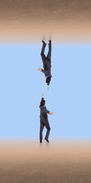 Businessman falling downward while reaching toward another hand in abstract space. Concept of risk failure support rescue, crisis situation and need for help in business environment.