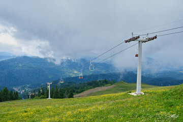 Obraz premium Summer Chairlift over Green Mountain Slopes and Wildflower Meadows