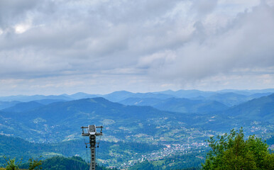 Obraz premium Ski Lift Mast Overlooking Mountain Town Valley