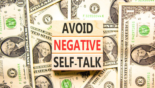 Avoid negative self-talk symbol. Concept words Avoid negative self-talk on beautiful wooden blocks. Beautiful dollar bills background. Business psychology avoid negative self-talk concept. Copy space.