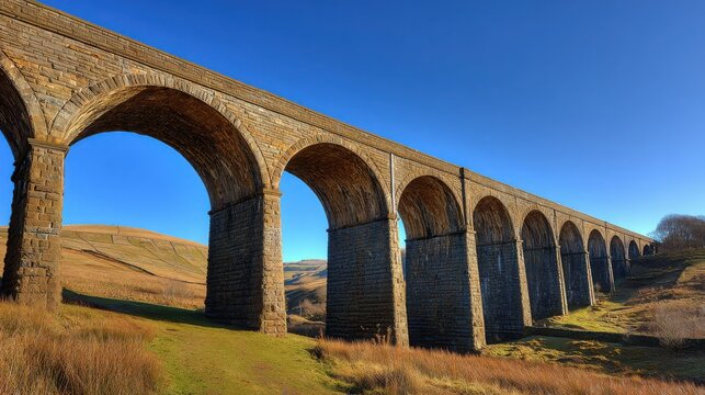 Grand Stone Viaduct with Multiple Parabolic Arches Against a Clear Blue Sky