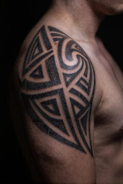Close-up detail of geometric black tribal tattoo patterns on skin