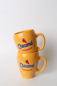 The Hague, Netherlands - March 19, 2026: Chocomel Branded Yellow Mugs Stacked on White Background