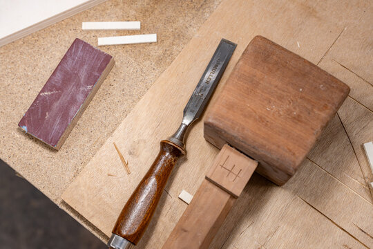 Objet en bois accompagn&eacute; d&rsquo;un ciseau &agrave; bois, illustrant le travail de pr&eacute;cision et le savoir-faire artisanal en menuiserie.