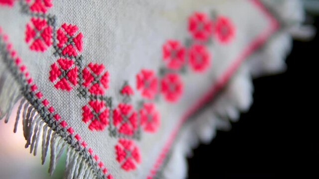 Traditional Ukrainian embroidered white doily with red and black floral cross stitch hanging on cabinet showcasing folk heritage and rustic vintage home decor