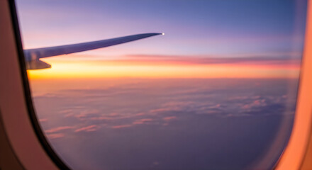 Obraz premium Airplane wing seen through window during sunset with clouds and sky