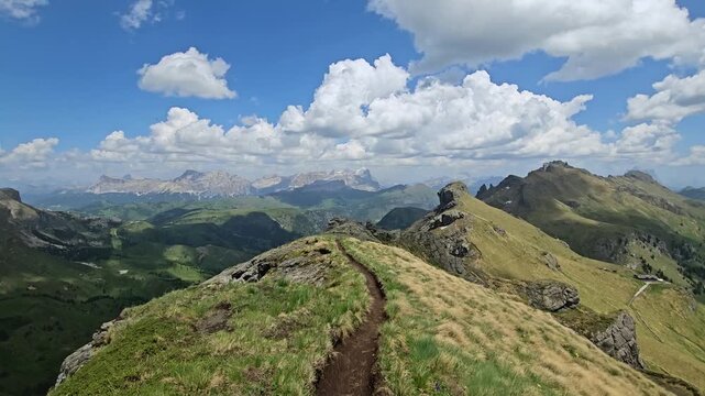 Scenic walk on Viel dal Pan with wide views of Italian Dolomites on sunny day.