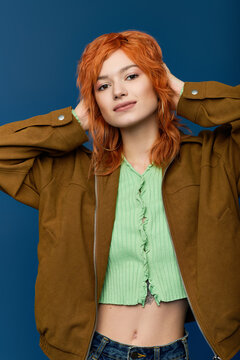 Spring fashion show with a young woman and vibrant red hair on a blue backdrop