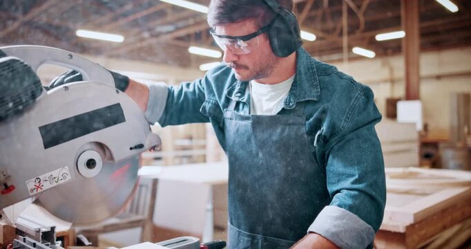 Carpentry, earmuffs and sawing machine with man in warehouse for manufacturing or production process. Bandsaw, eyewear and ppe with person in woodworking plant to resize lumber or timber for project